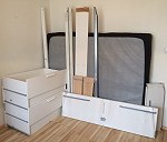 Łóżko rozłożone na kilka części (rama, dno łóżka, materac + 4 szuflady), dwa krzesła balkonowe, mały stolik balkonowy, dwa kartony, dwie walizki, trzy torby typu bagaż podręczny, hantle (2x12kg), 2 antyramy